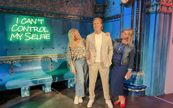 Wax figure at Madame Tussauds Budapest with visitors posing for photos.