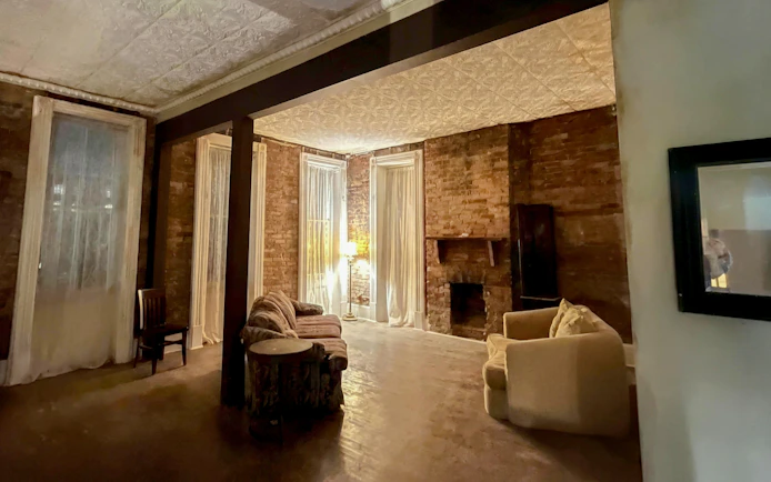 Historic Savannah room with brick walls and vintage furniture, part of a paranormal investigation tour.