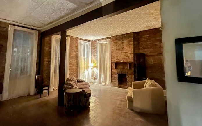 Historic Savannah room with brick walls and vintage furniture, part of a paranormal investigation tour.