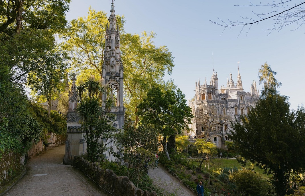 Quinta da Regaleira's ornate facade with lush gardens in Sintra, Portugal.