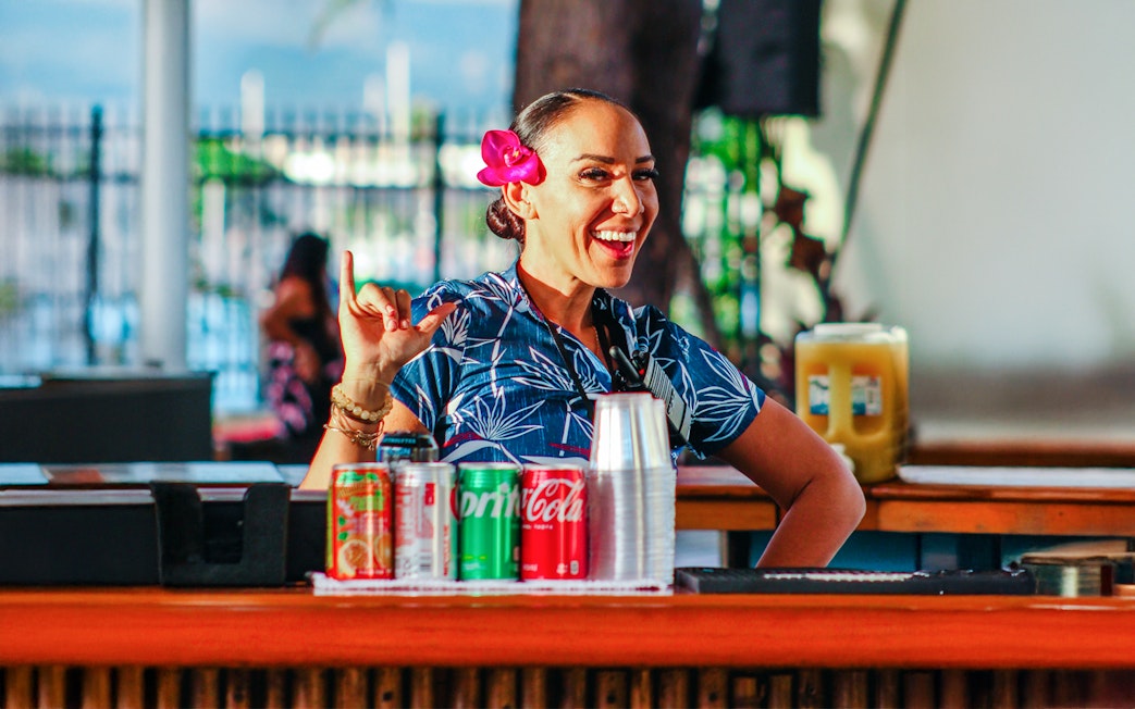 Hawaiian woman with flower in hair at Moana Luau bar, Hawaii.