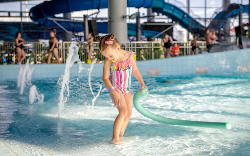 Child playing in the pool at Therme Erding Tropical Spa entrance.