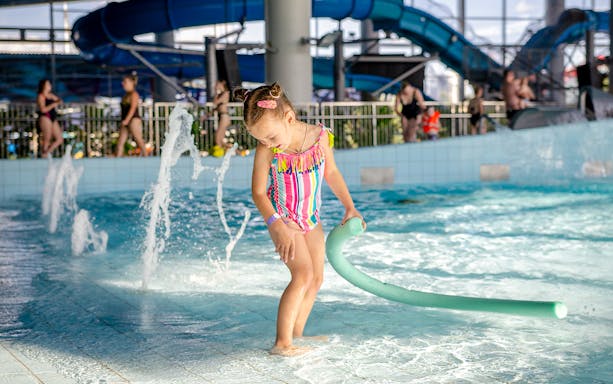 Child playing in the pool at Therme Erding Tropical Spa entrance.