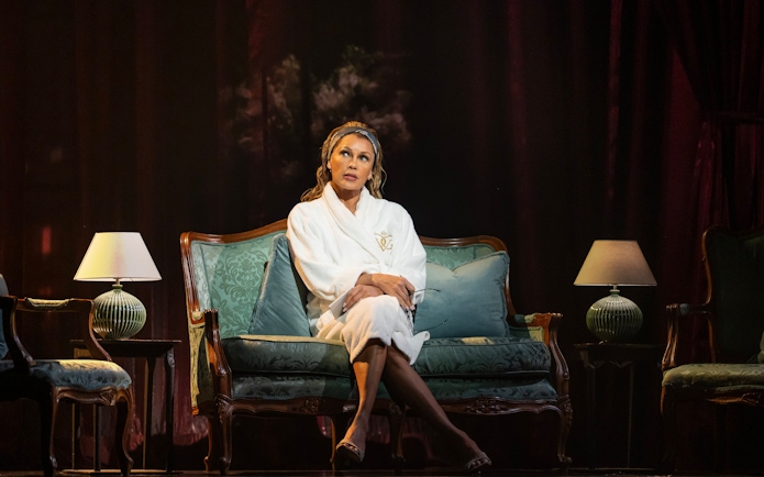 Actor seated on stage during The Devil Wears Prada West End show performance.