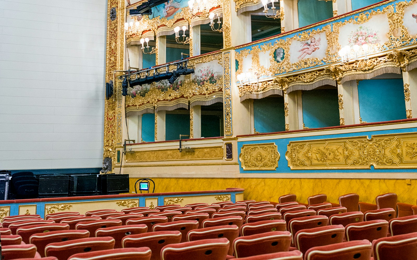 Teatro La Fenice auditorium with ornate balconies and red seats, Venice.