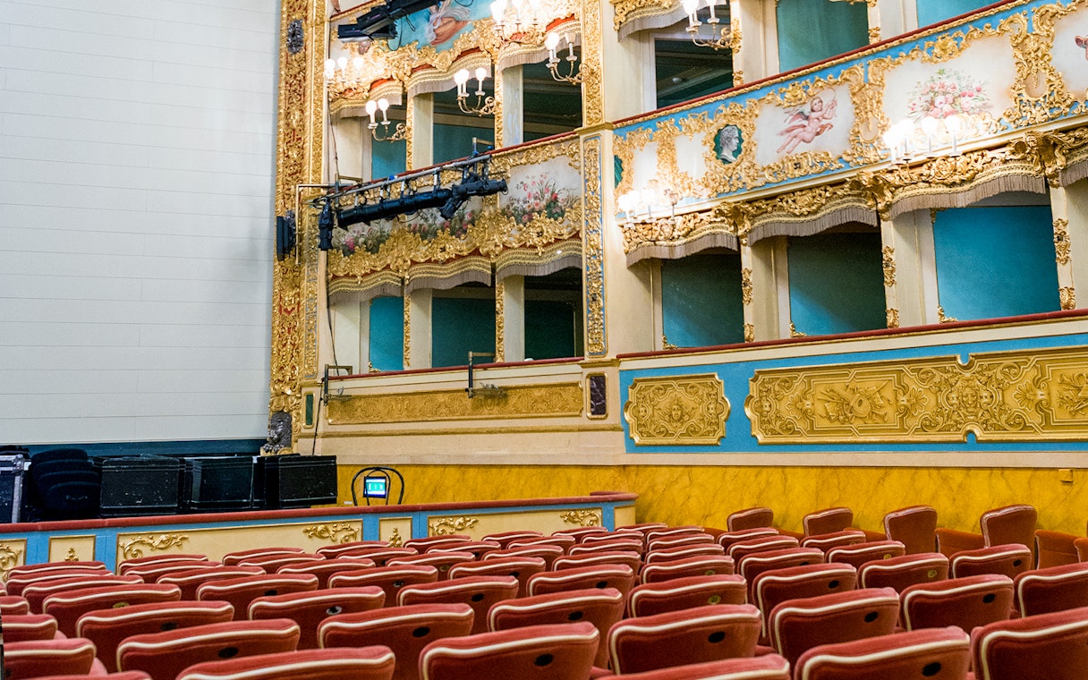 Teatro La Fenice auditorium with ornate balconies and red seats, Venice.