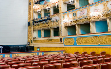 Teatro La Fenice auditorium with ornate balconies and red seats, Venice.