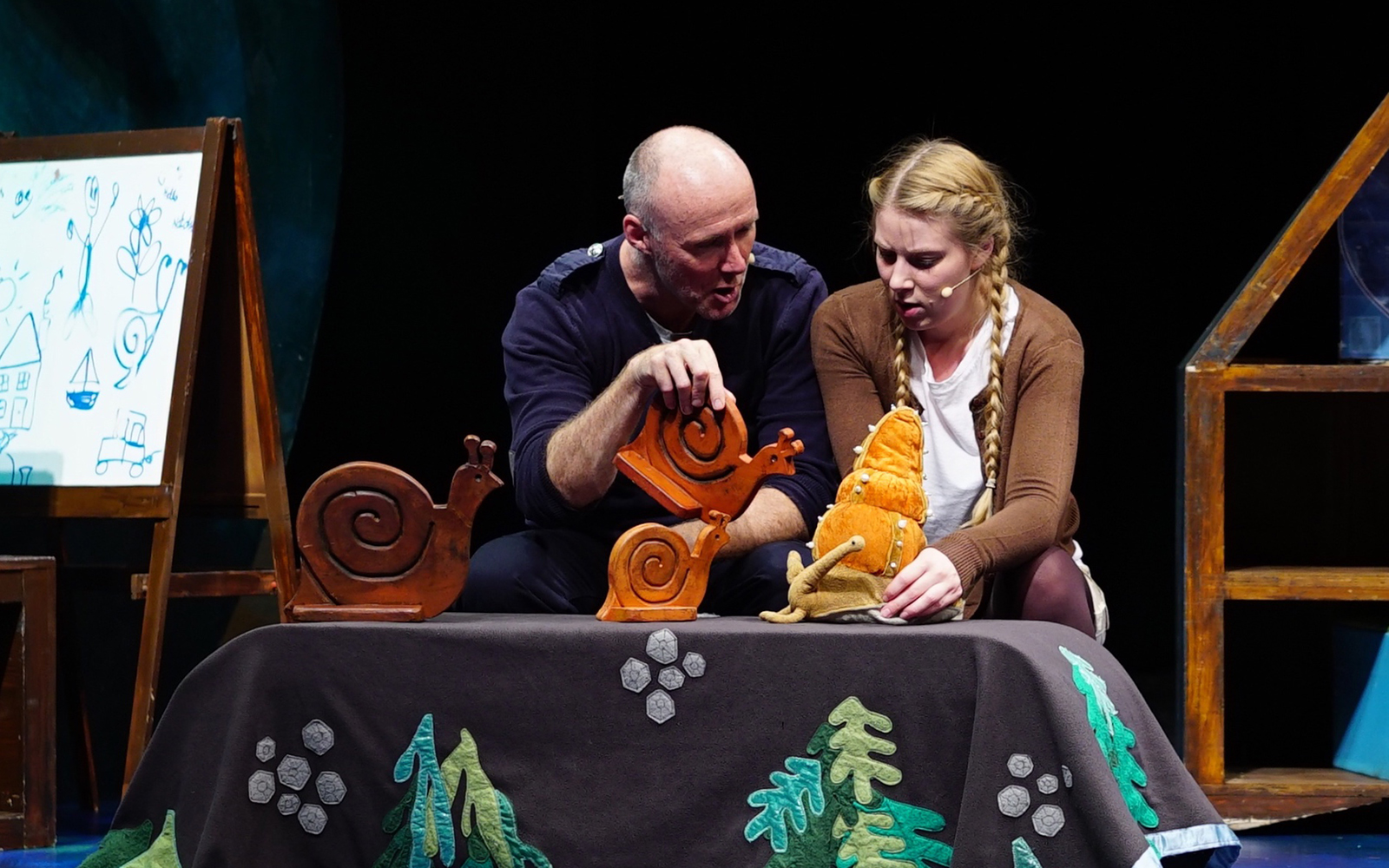 Actors performing "The Snail and the Whale" with puppets on stage.