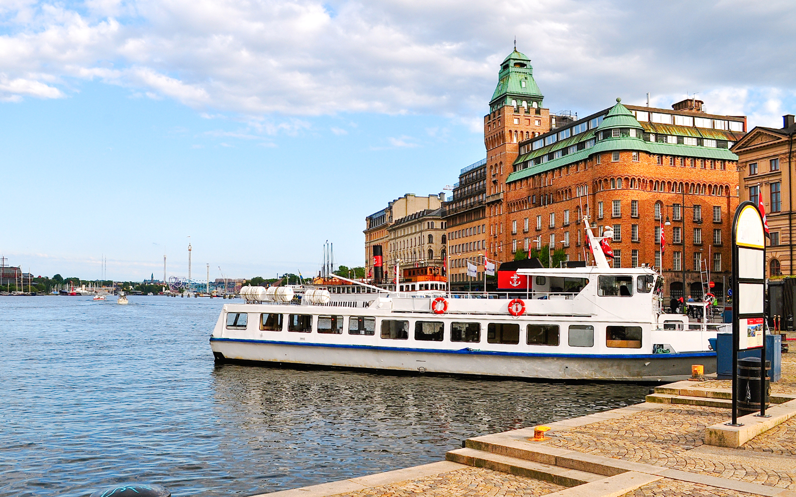 Tour boat docked near historic buildings on an archipelago sightseeing cruise.