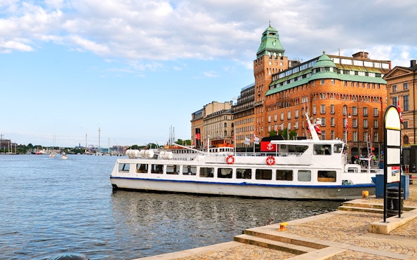 Tour boat docked near historic buildings on an archipelago sightseeing cruise.