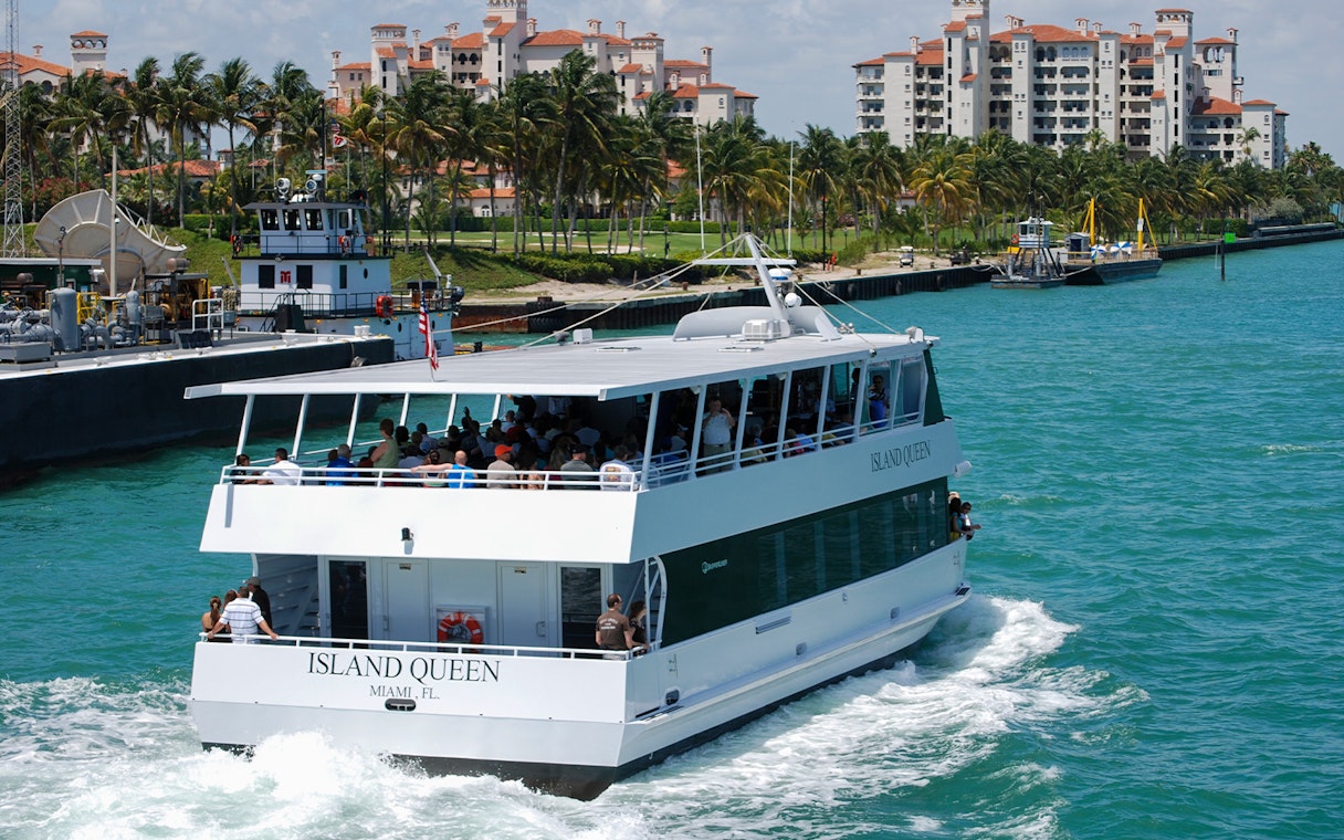 Tour boat cruising near waterfront buildings in Orlando, part of the Explorer City Pass experience.