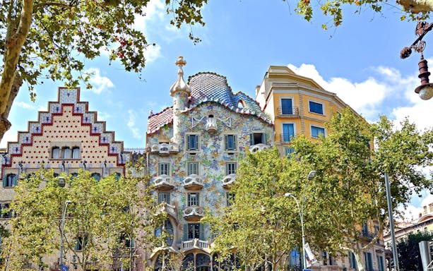 Casa Batlló facade with colorful mosaic tiles in Barcelona, near Casa Mila.