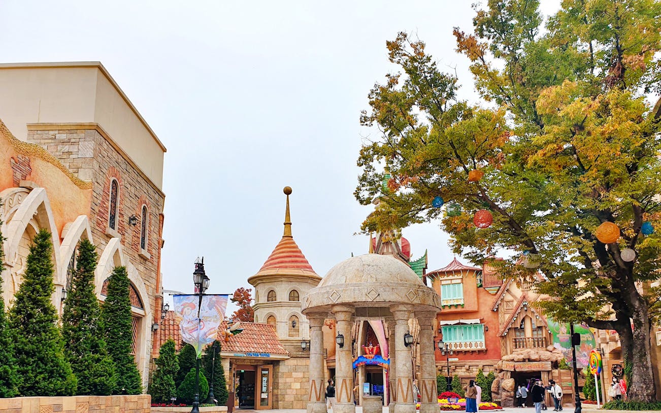 Gyeongju World entrance with colorful architecture and trees, South Korea.