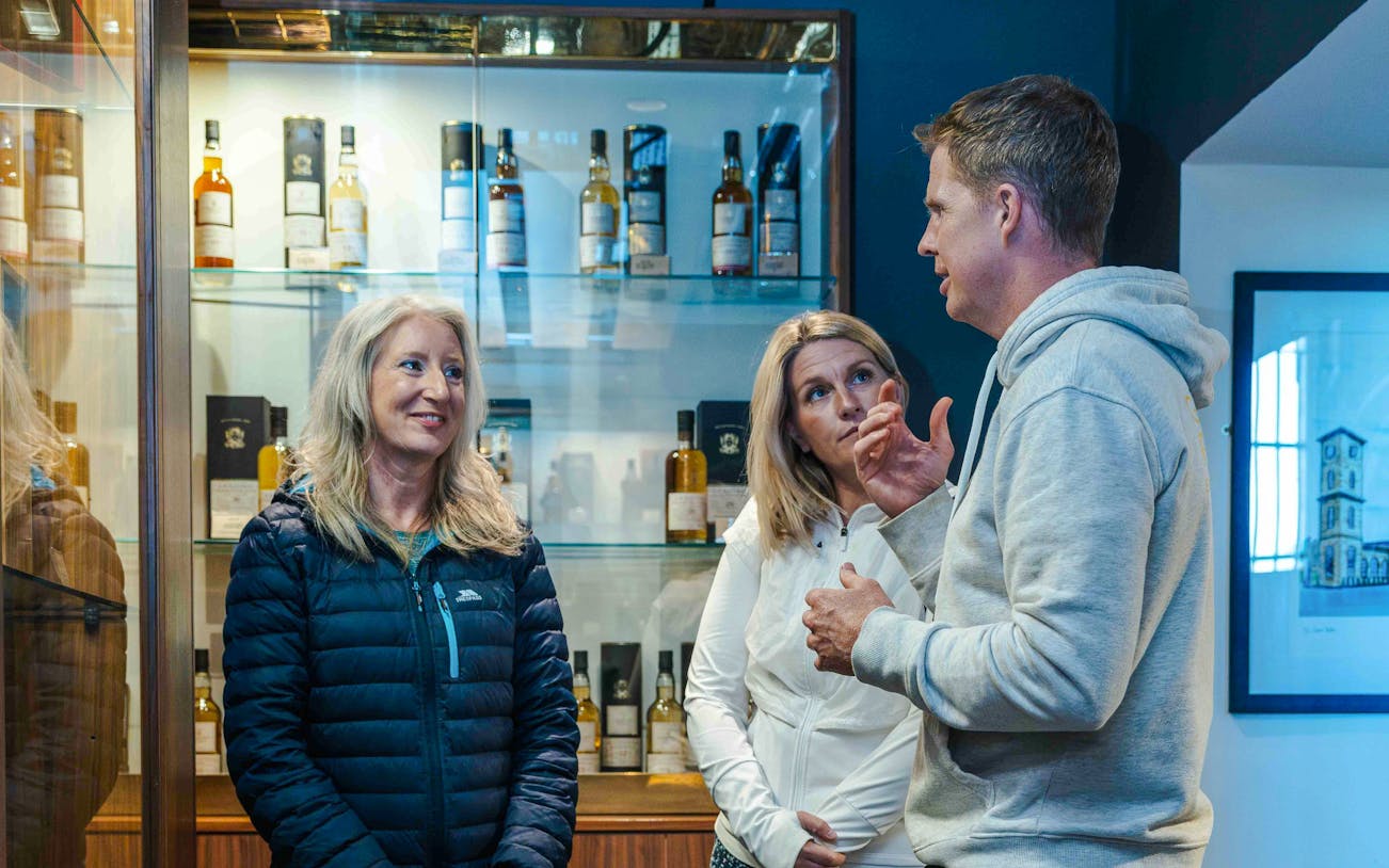 Guests discussing whiskey varieties at a tasting event in Glasgow.