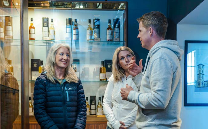 Guests discussing whiskey varieties at a tasting event in Glasgow.