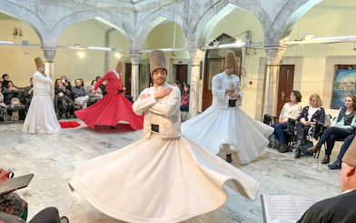 Whirling dervishes performing in Istanbul with an audience watching.