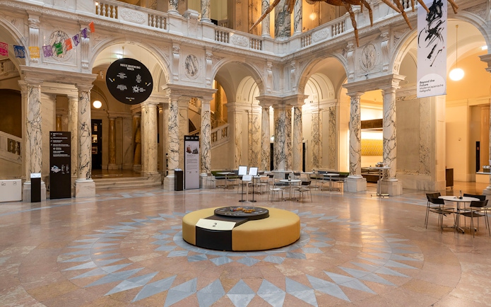 Inside view of the New Hofburg Palace with marble columns and seating area.