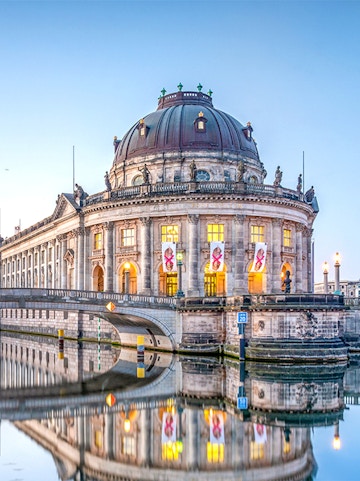 Bode Museum on Museum Island, Berlin, reflected in the Spree River at dusk.