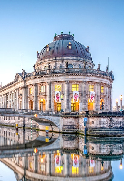 Bode Museum on Museum Island, Berlin, reflected in the Spree River at dusk.