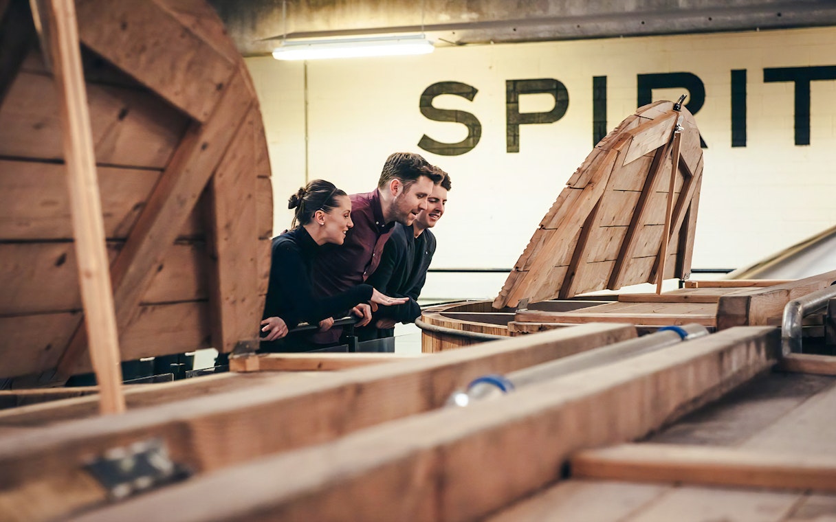 Visitors observing whiskey barrels at Teeling Whiskey Distillery.
