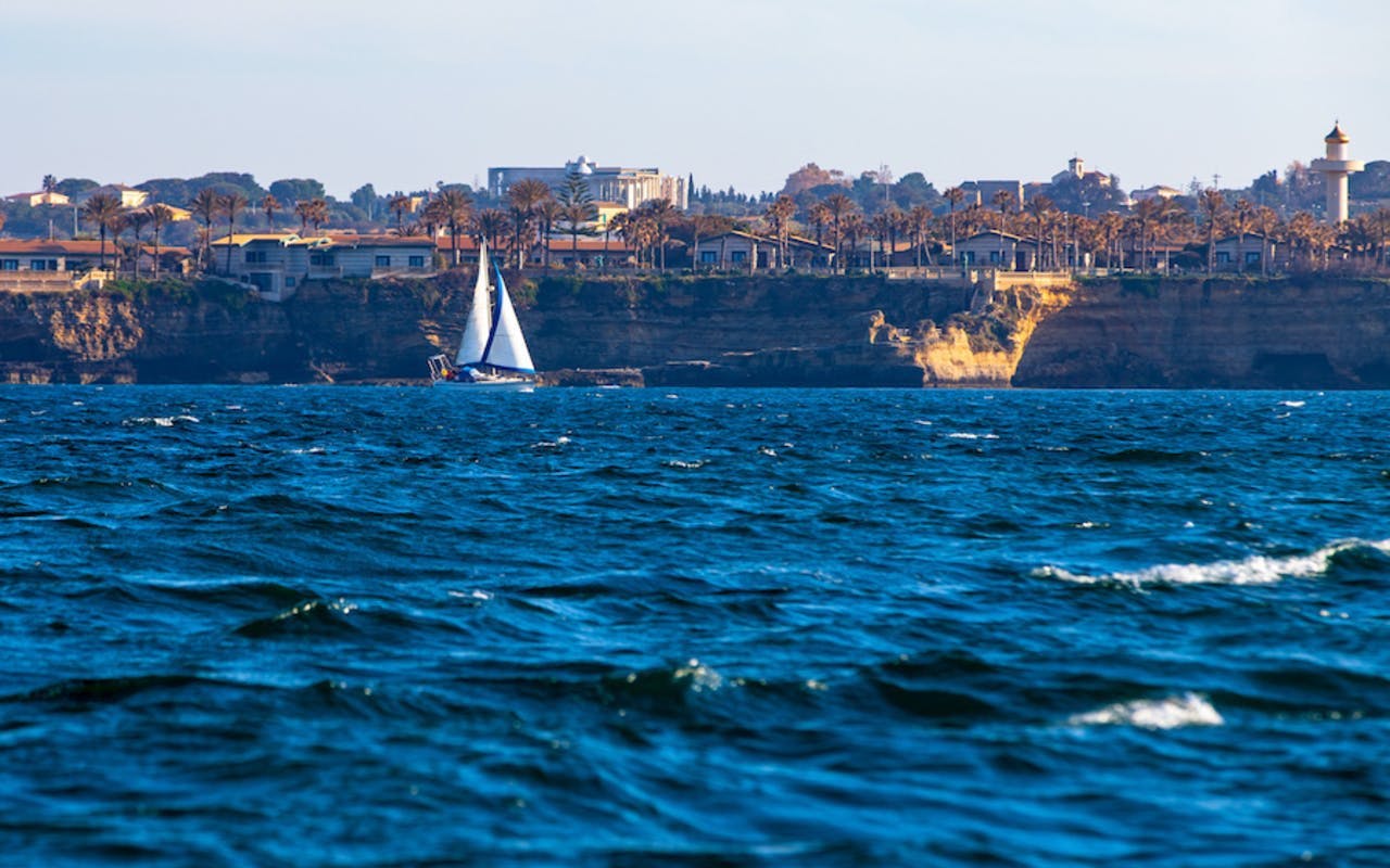 Sailboat on Ortigia coast during sunset tour with aperitif.