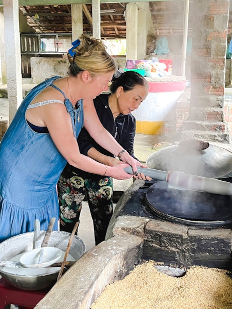 Women making rice paper in a traditional Vietnamese workshop.