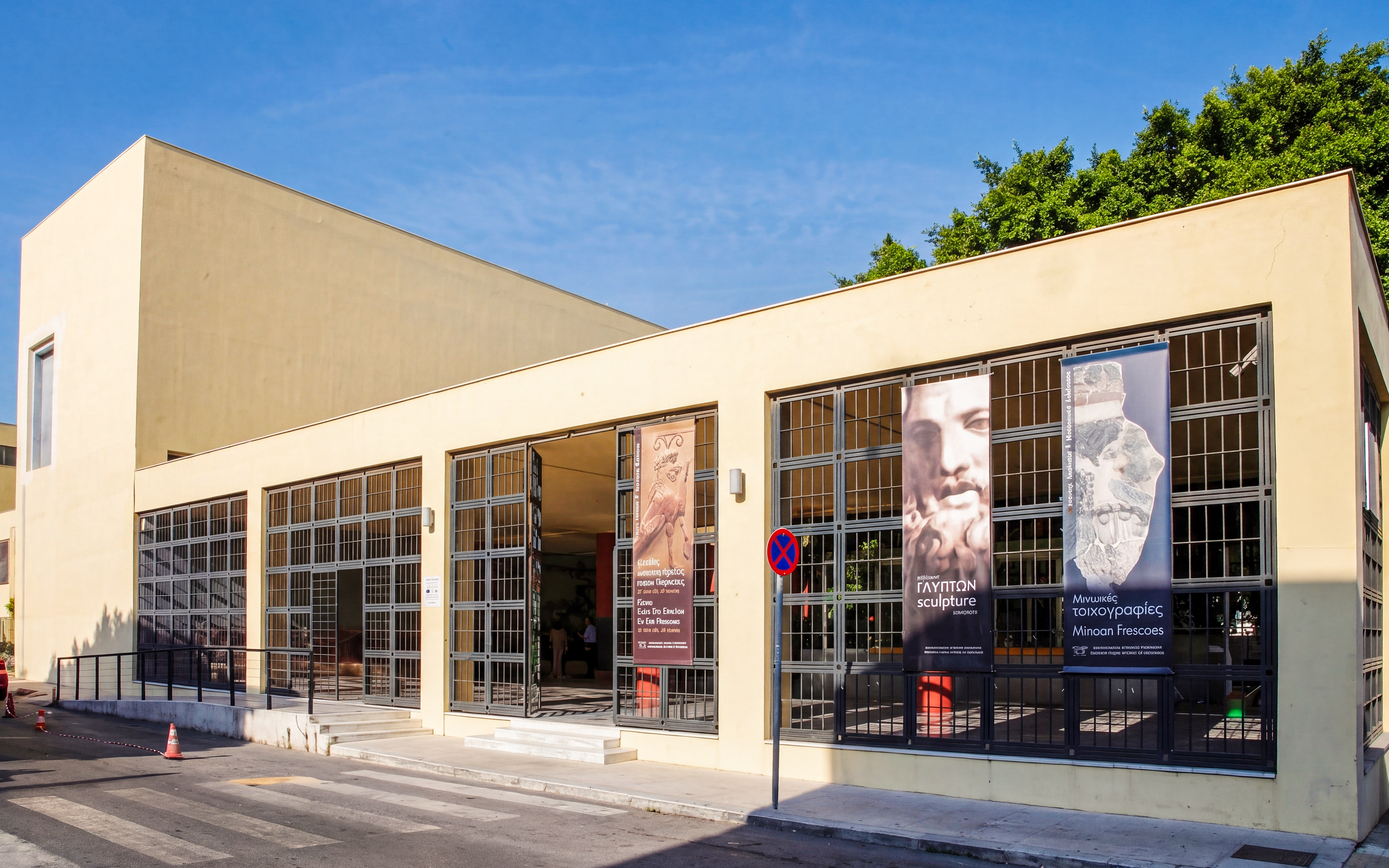 Heraklion Archaeological Museum entrance with banners displaying sculptures and frescoes.