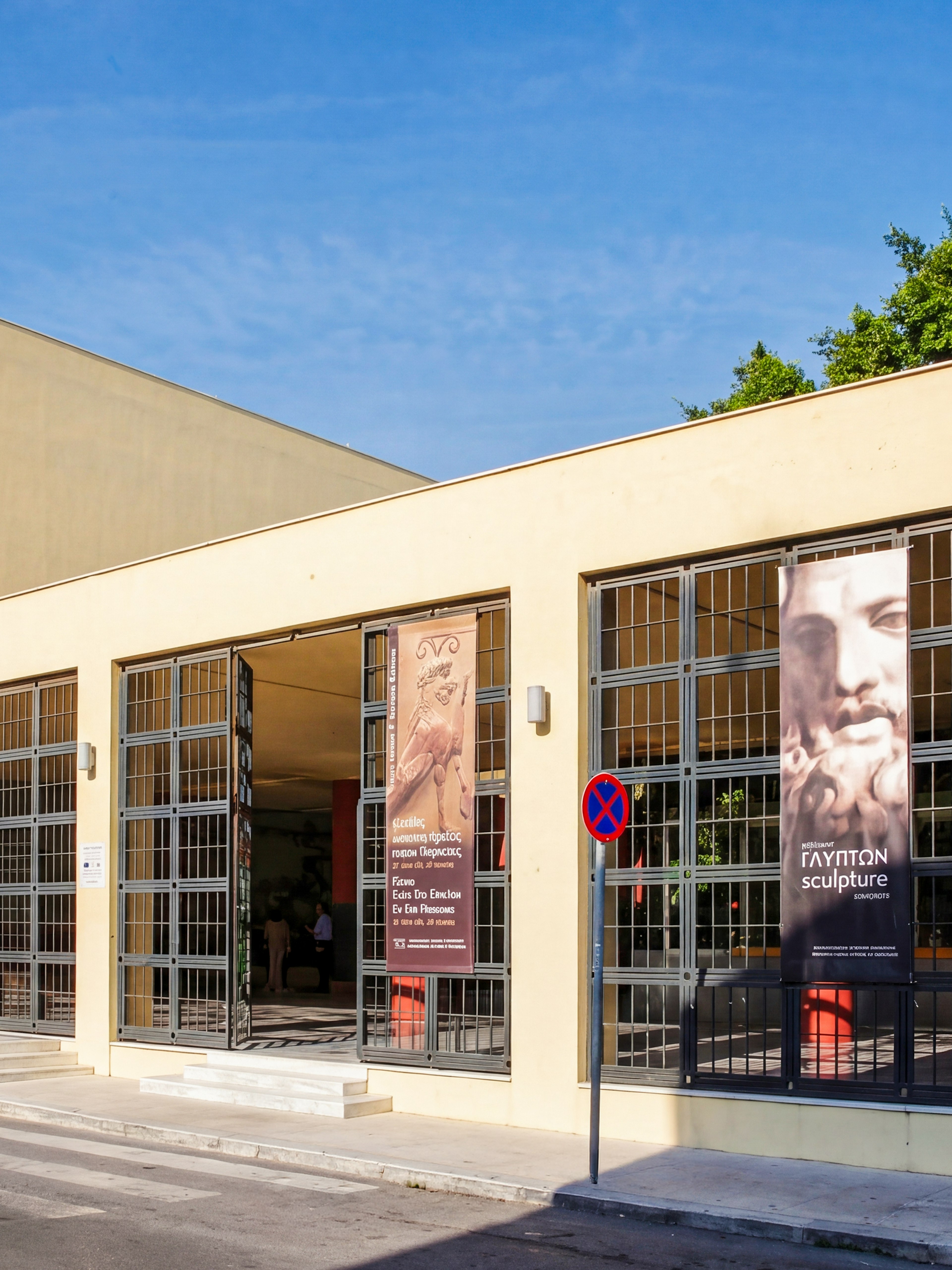 Heraklion Archaeological Museum entrance with banners displaying sculptures and frescoes.