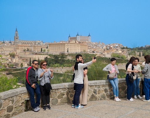 Tourists taking photos at Mirador del Valle viewpoint in Toledo, Spain.