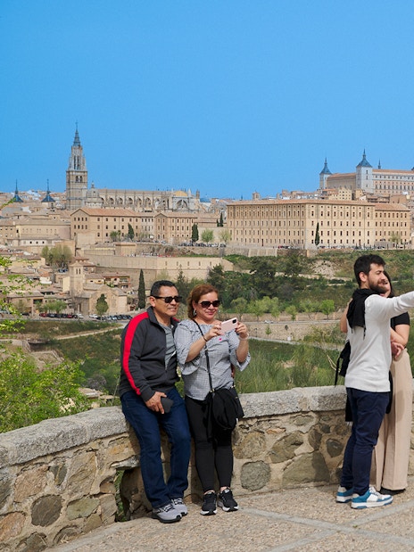 Tourists taking photos at Mirador del Valle viewpoint in Toledo, Spain.