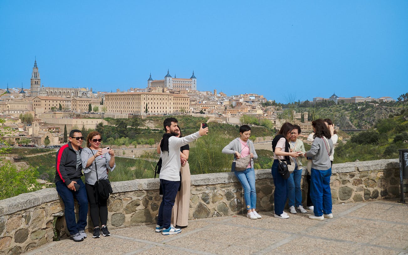 Tourists taking photos at Mirador del Valle viewpoint in Toledo, Spain.