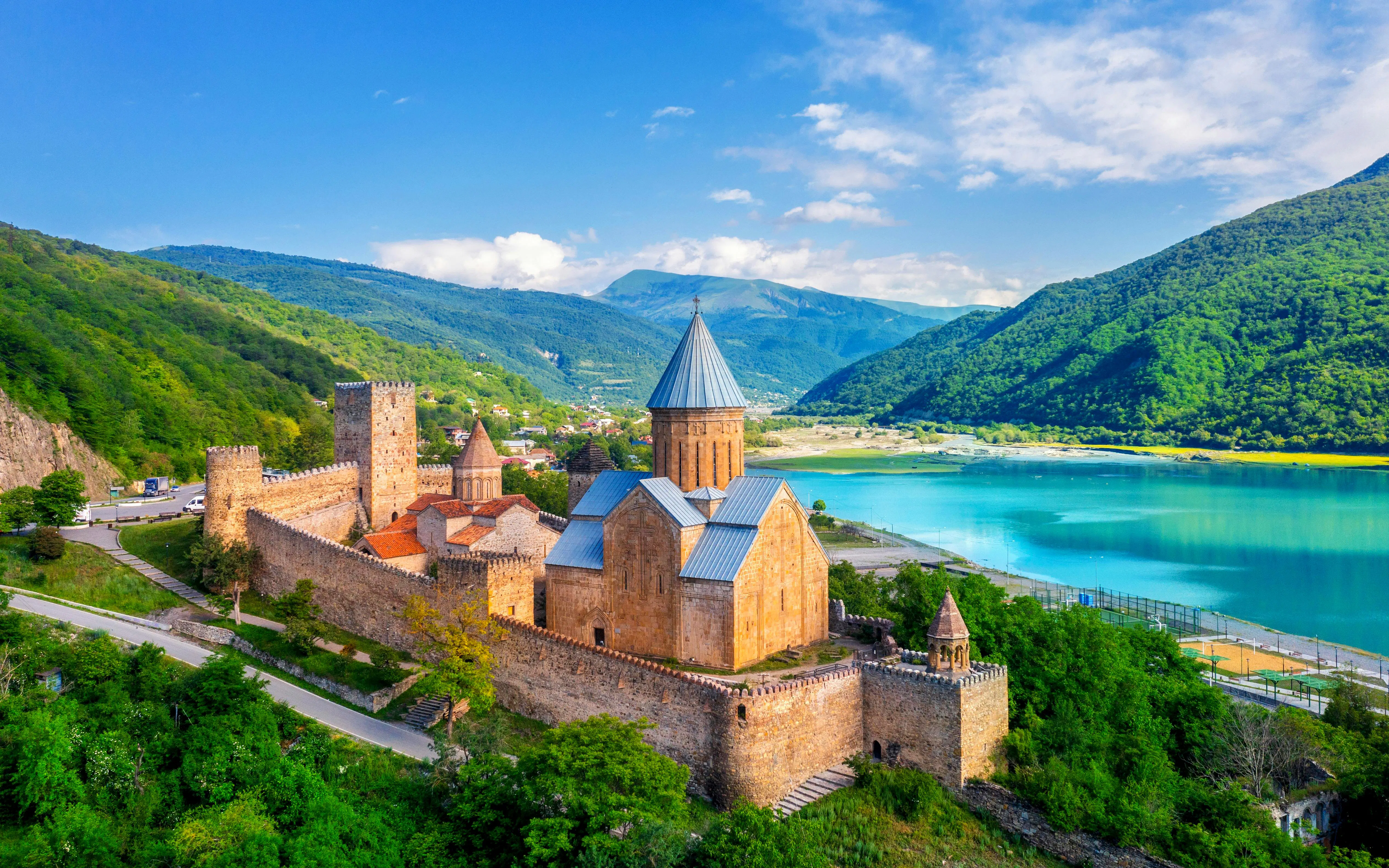 Aerial view of Ananuri Fortress Complex by a turquoise lake in Georgia.