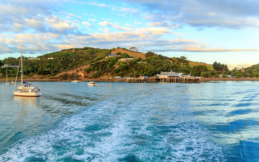 Matiatia Bay view from ferry, Waiheke Island, with boats and lush hills.