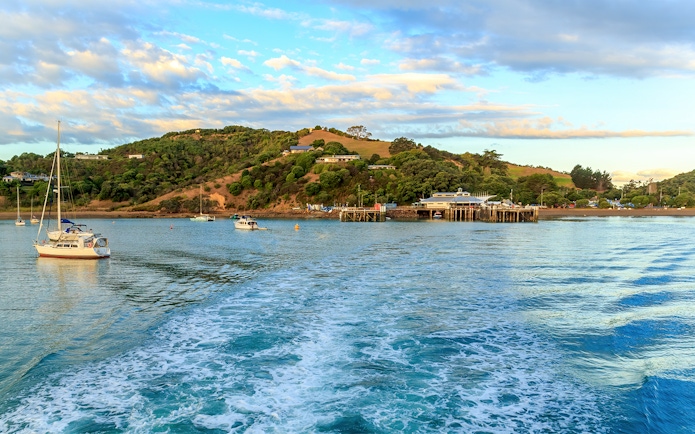 Matiatia Bay view from ferry, Waiheke Island, with boats and lush hills.
