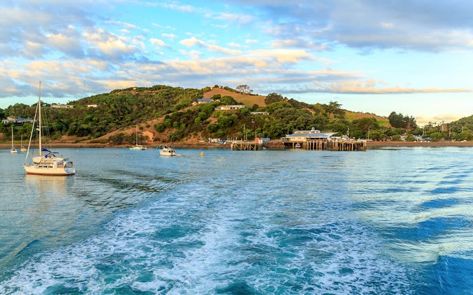 Matiatia Bay view from ferry, Waiheke Island, with boats and lush hills.