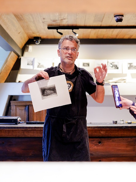 Guide explaining artwork inside Rembrandt House Museum, Amsterdam.