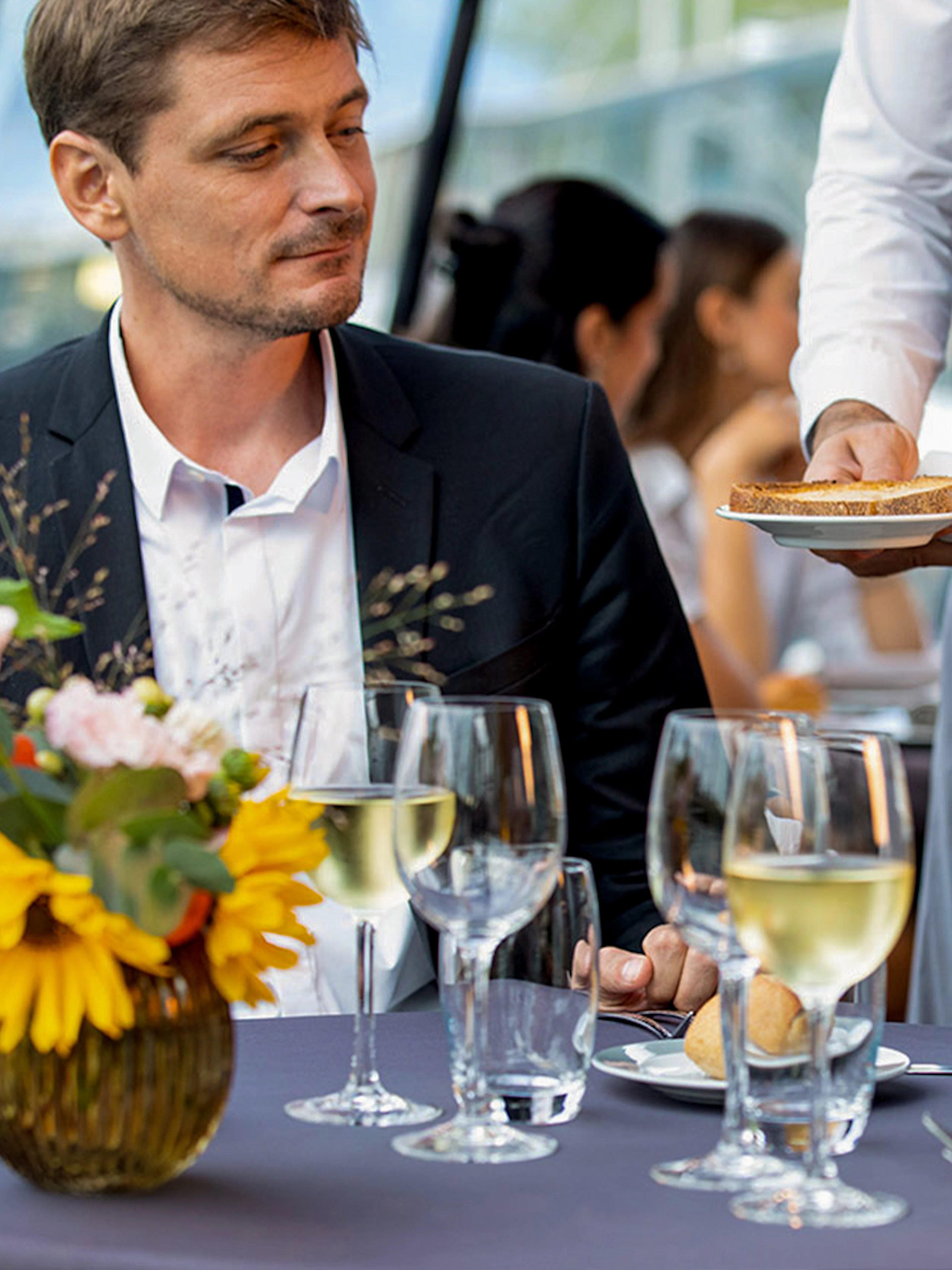 Server presenting gourmet dishes on a Seine River dinner cruise at 6:15pm.