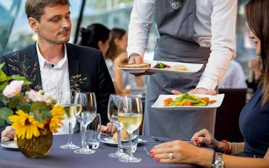 Server presenting gourmet dishes on a Seine River dinner cruise at 6:15pm.