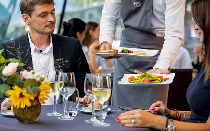 Server presenting gourmet dishes on a Seine River dinner cruise at 6:15pm.