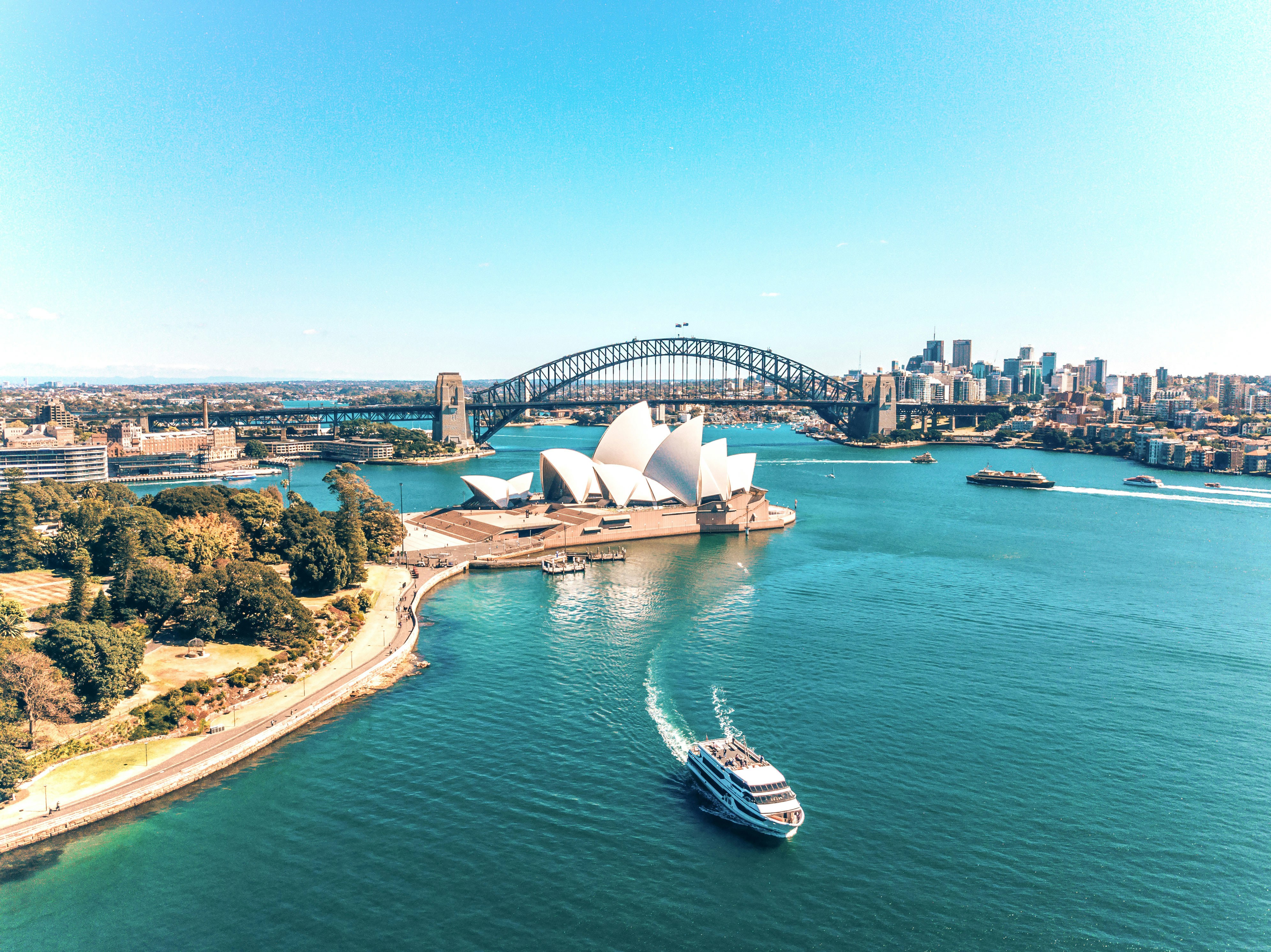 Aerial view of Sydney Opera House and Harbour Bridge with ferry in Sydney, Australia.
