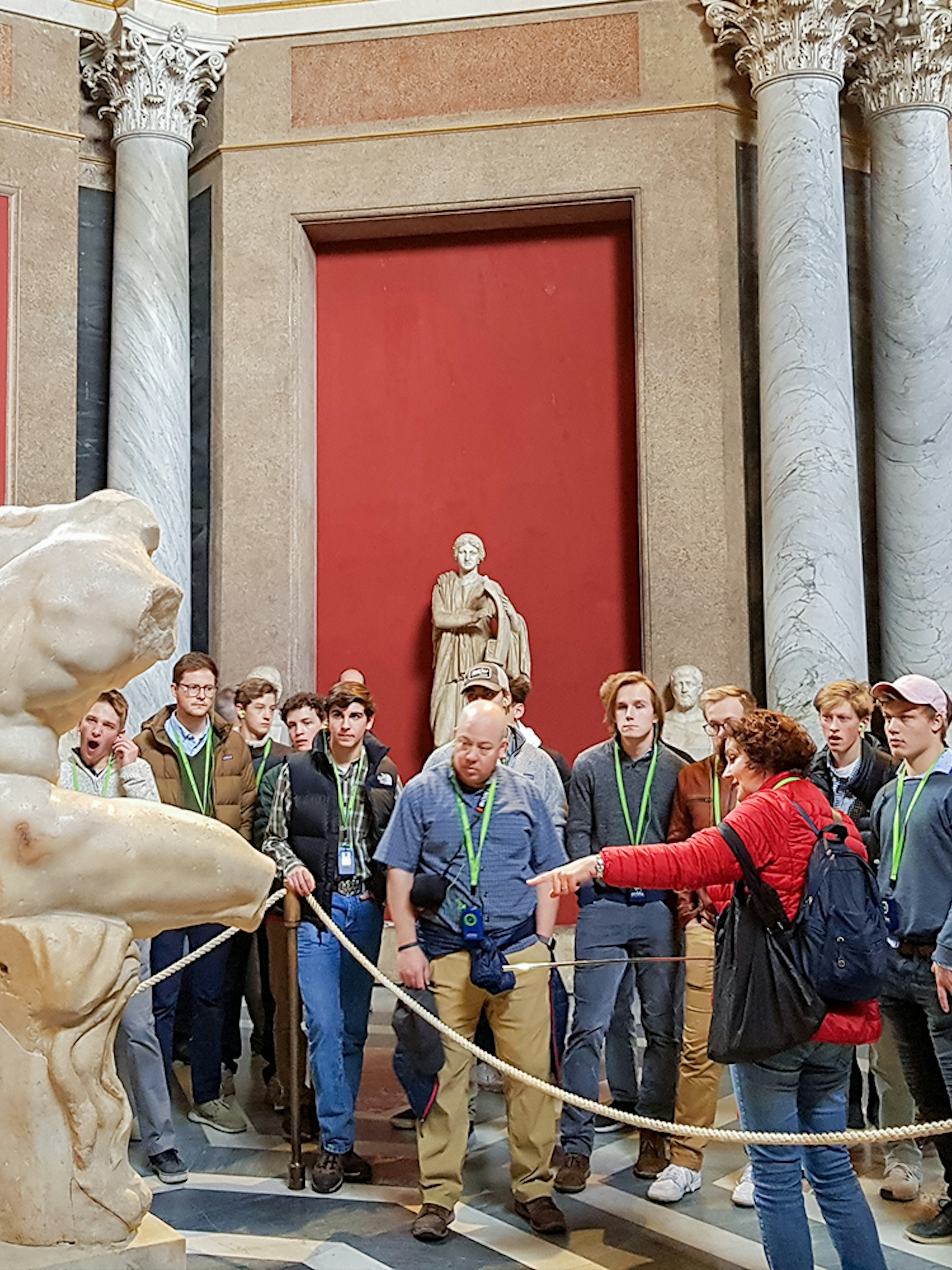 Tour group observing ancient sculptures in the Vatican Museums.