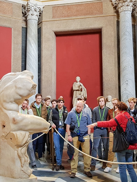 Tour group observing ancient sculptures in the Vatican Museums.