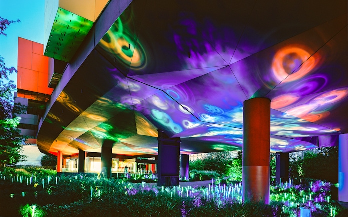 Colorful light display at night under the Musee du Quai Branly in Paris.