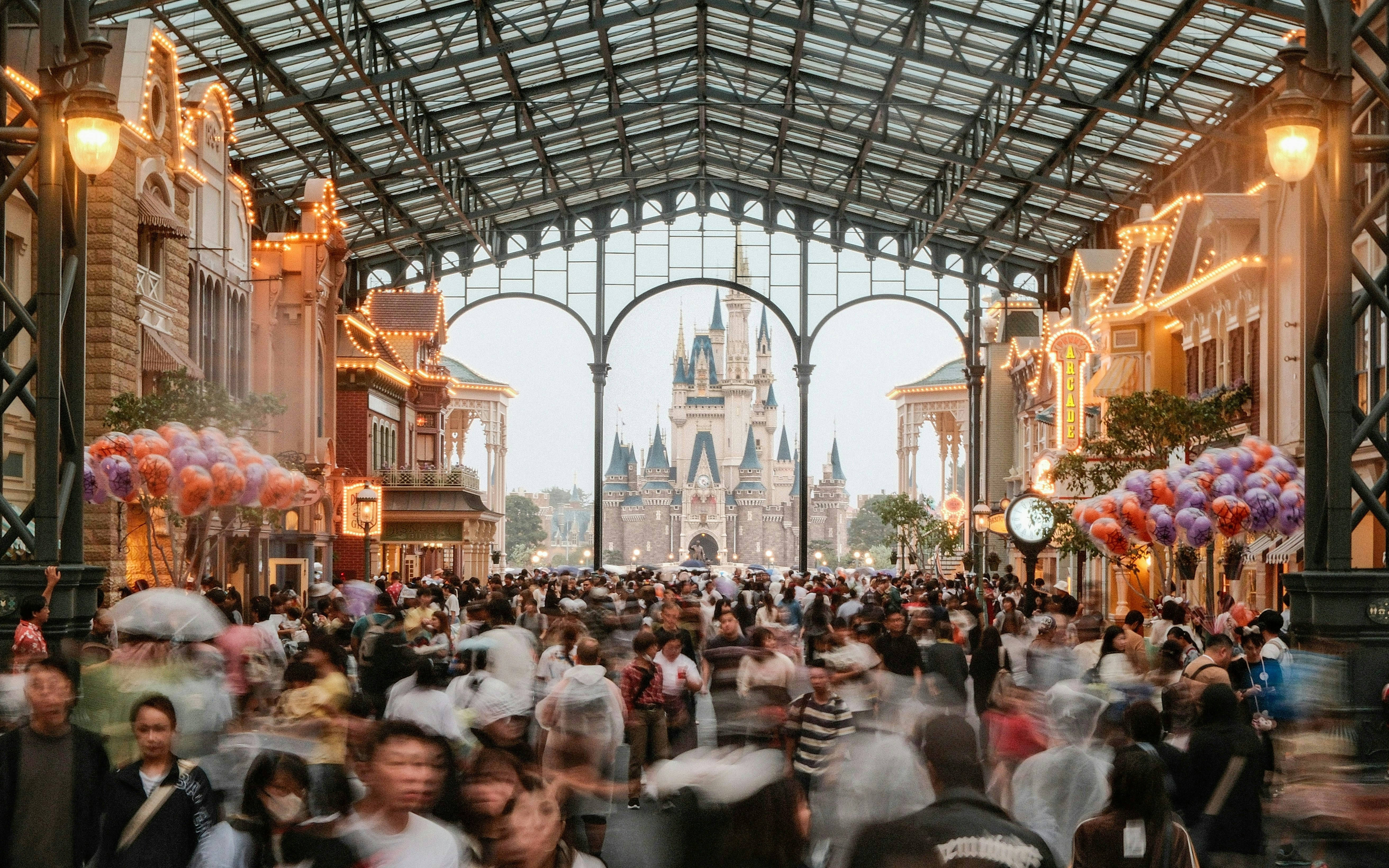 Crowded World Bazaar at Tokyo Disneyland with Cinderella Castle in the background.