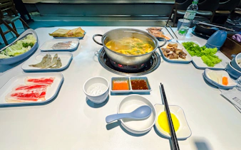 Hot pot dinner setup with seafood, vegetables, and sauces on Phu Quoc Sunset Tour.