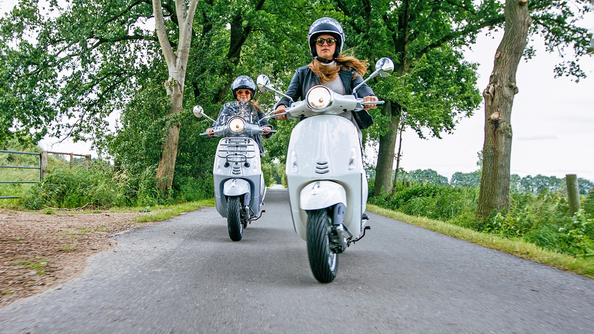 Motorbikes on a scenic road in, surrounded by lush greenery.