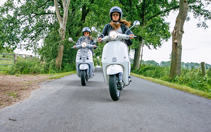 Motorbikes on a scenic road in Langkawi, surrounded by lush greenery.