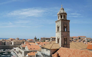 Dubrovnik Old Town rooftops and bell tower with Adriatic Sea in the background.