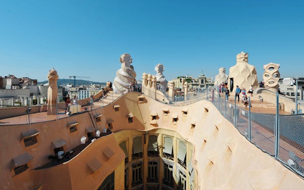 Rooftop view of Casa Mila with unique chimneys, part of a guided tour in Barcelona.