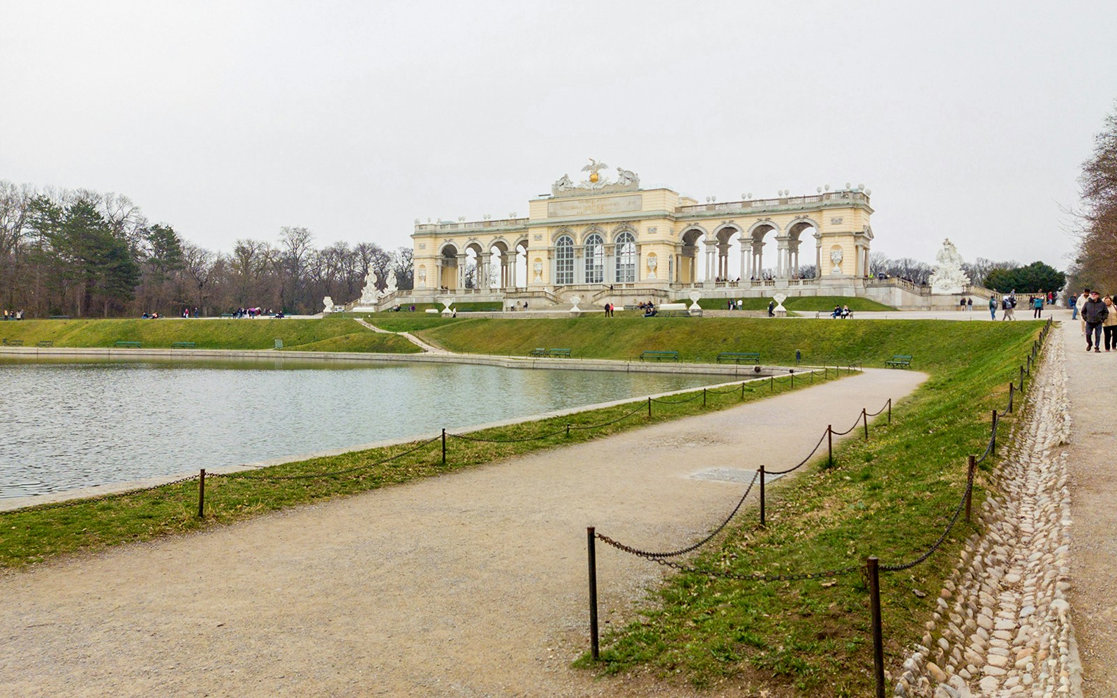 Gloriette at Schönbrunn Palace with reflecting pond and walking path, Vienna, Austria.
